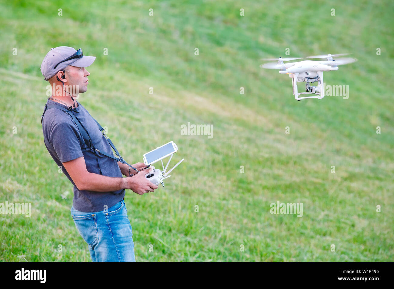 Young Man watching and navigating a flying drone Stock Photo