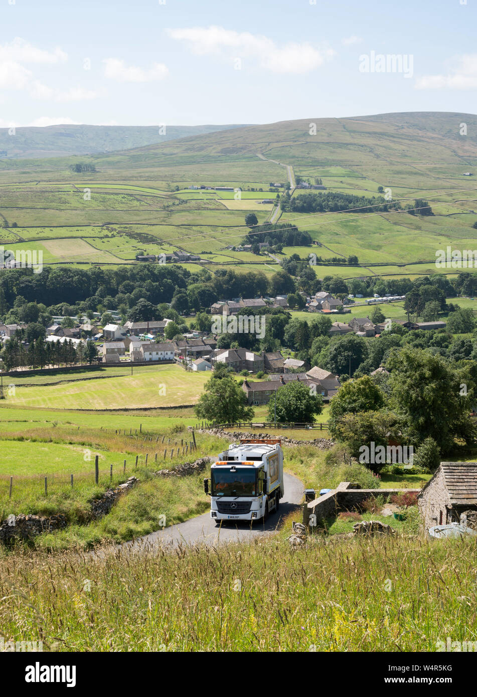 A bin wagon carrying out rural refuse collection above Westgate village, in Weardale, Co. Durham, England, UK Stock Photo