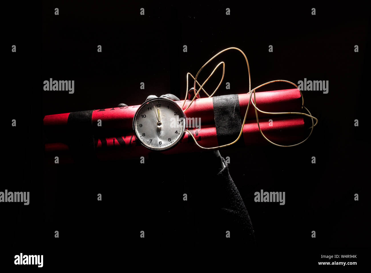 Dynamite bomb with a timer, and a bunch of dynamite on black background. Dynamite is going to explode or detonate per 1 second. Stock Photo
