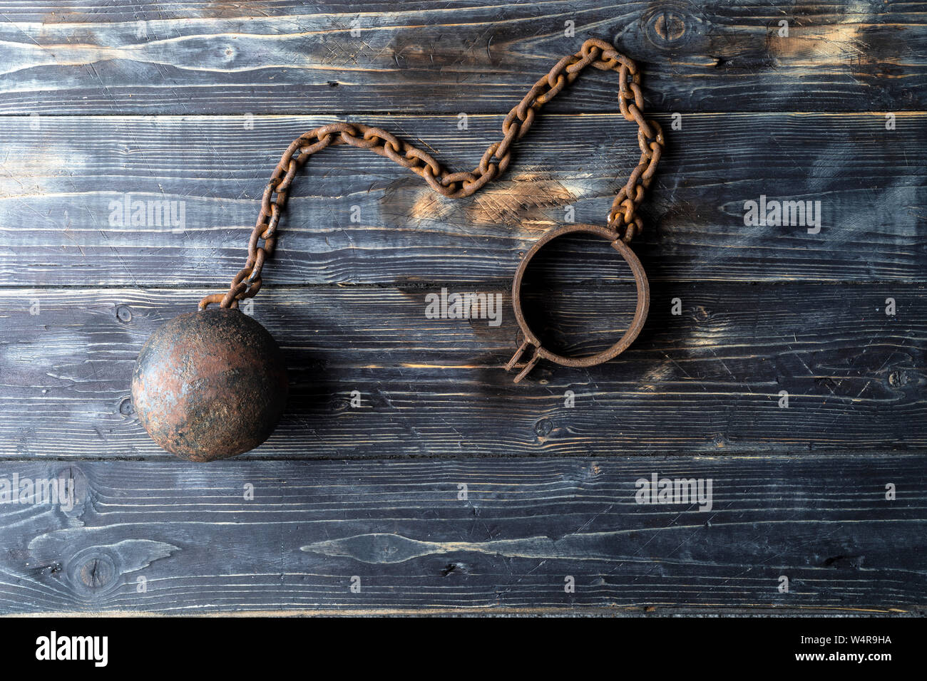 Metal ball with chain on the leg. Prison equipment. Stock Photo
