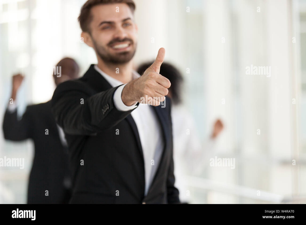 Excited smiling employee, manager show thumbs up close up Stock Photo ...
