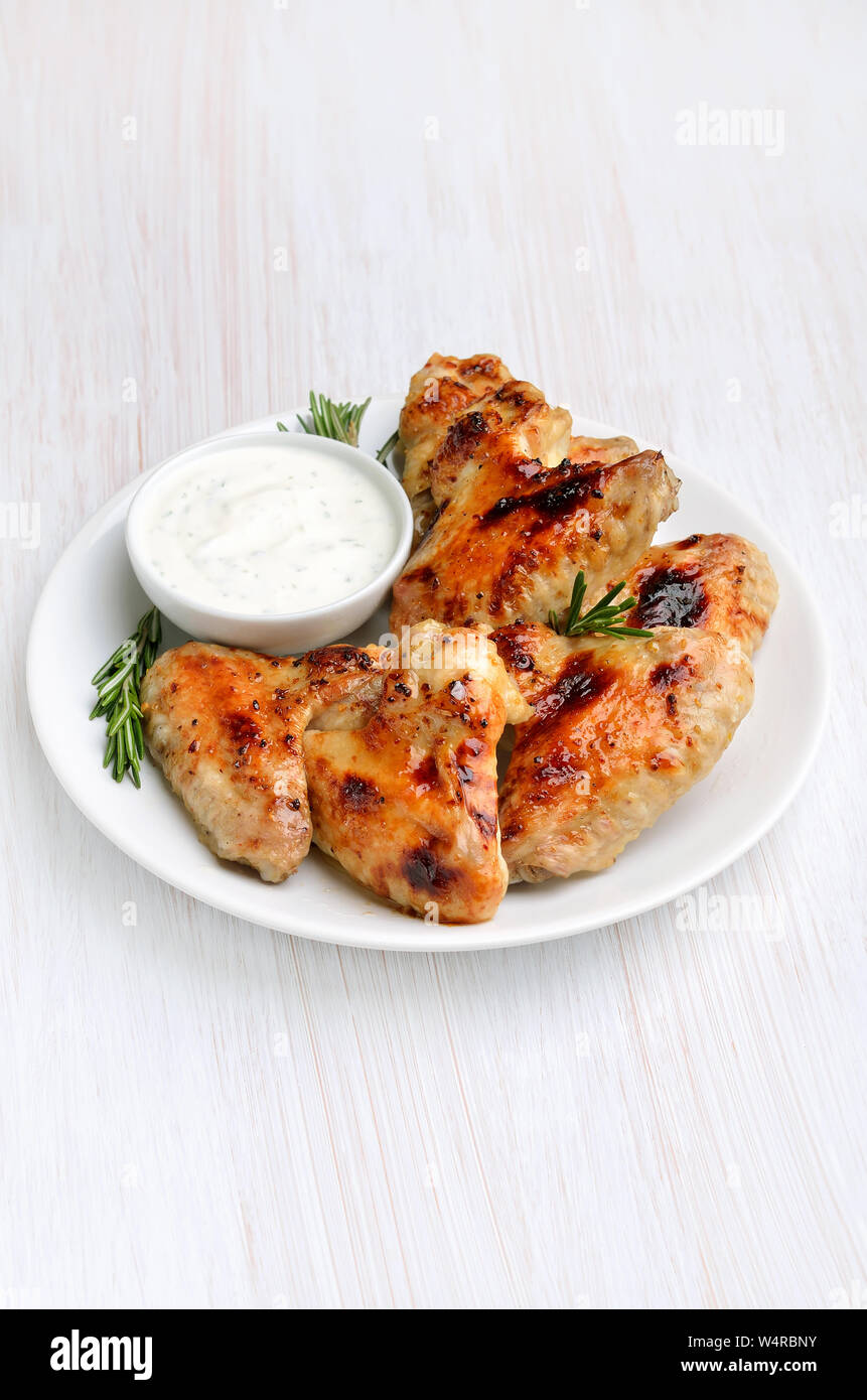 Grilled chicken wings with sauce on white plate Stock Photo