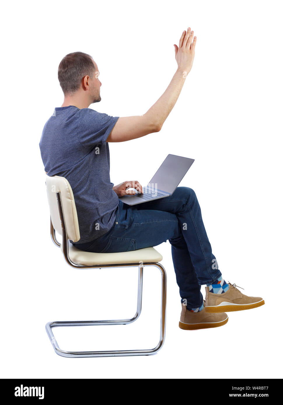 Side View Of A Man Who Sits On A Chair With A Laptop And Points With 