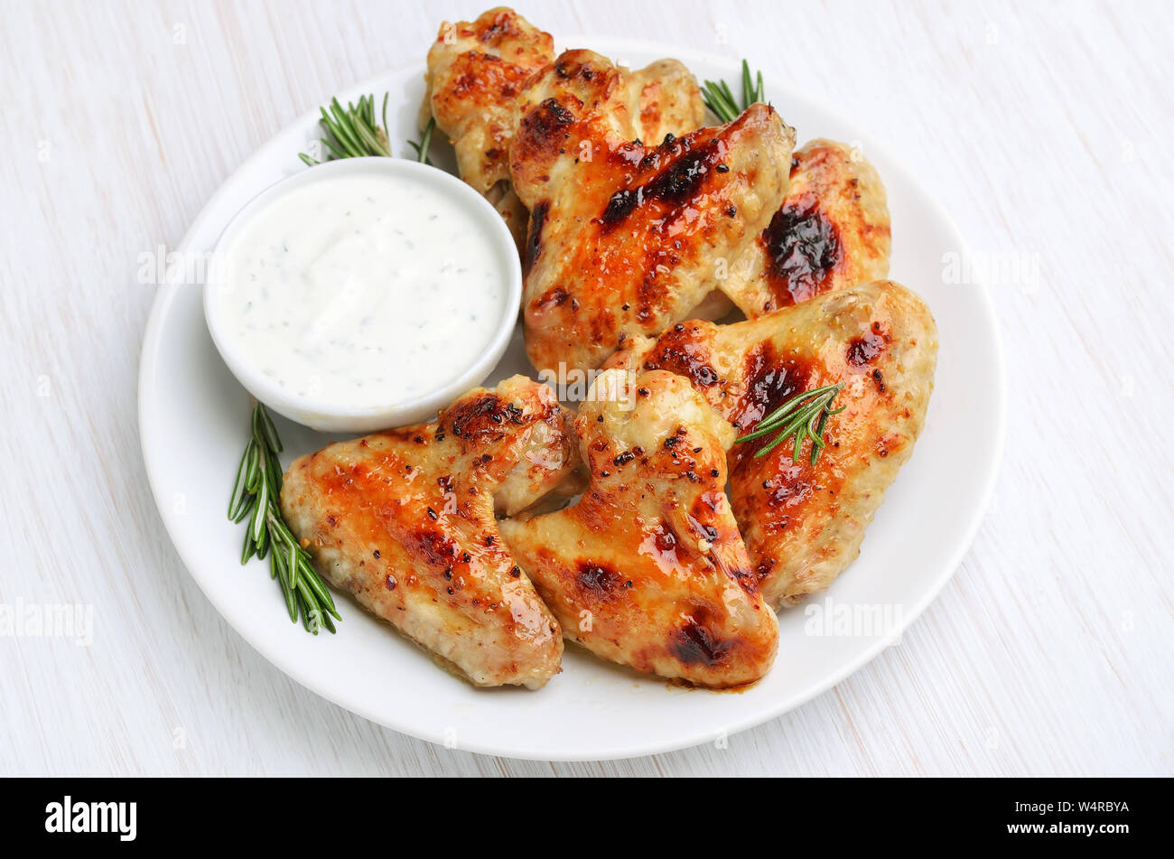 Baked chicken wings with sauce on white plate Stock Photo