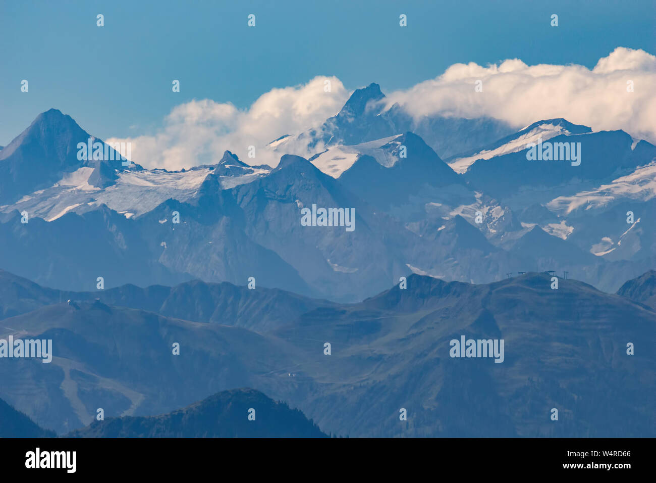 Moody picture of blue silhouette of mountain ridges far away, the highest peak of Austrian alps, Grossglockner, blue background Stock Photo