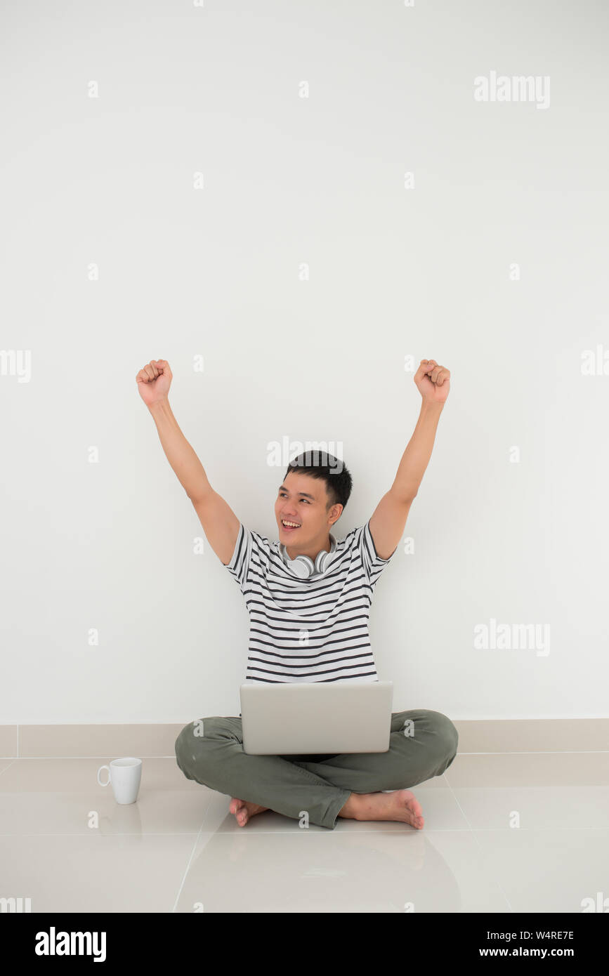 Successful man online with arms up - isolated over white background Stock Photo