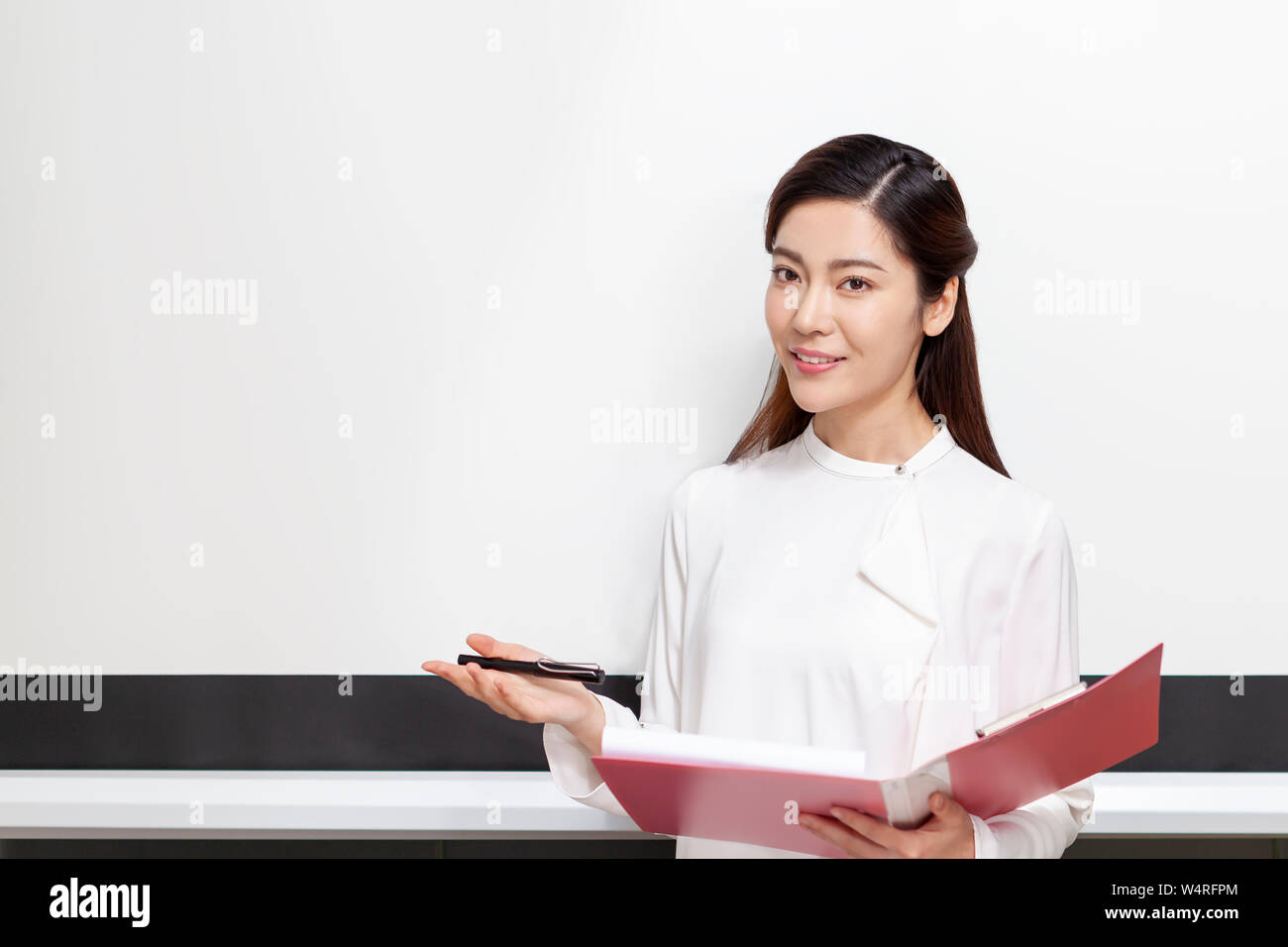 Woman in front of whiteboard, Beijing China Stock Photo