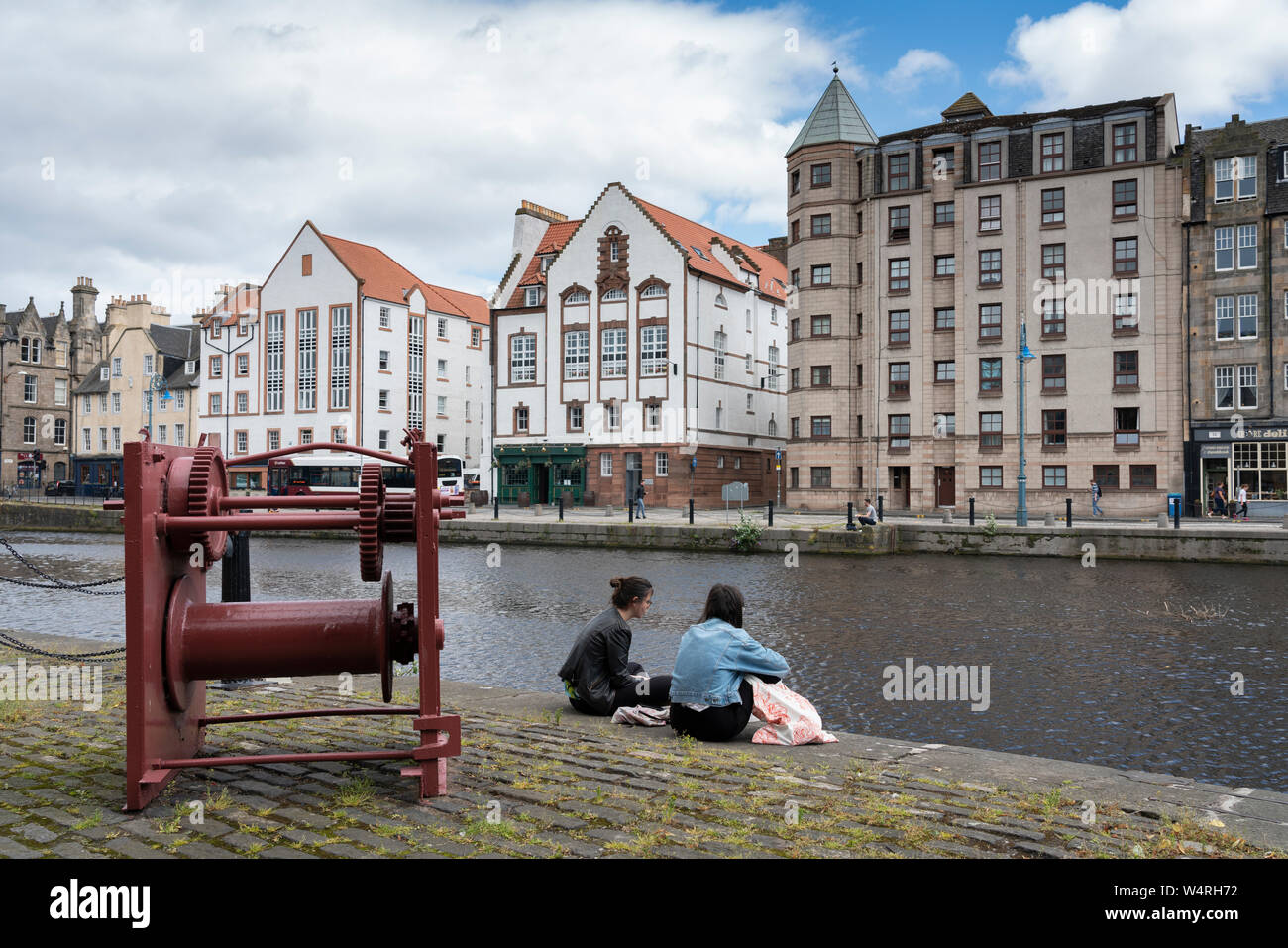 Couple sitting beside Water of Leith river in Leith , Scotland, UK Stock Photo