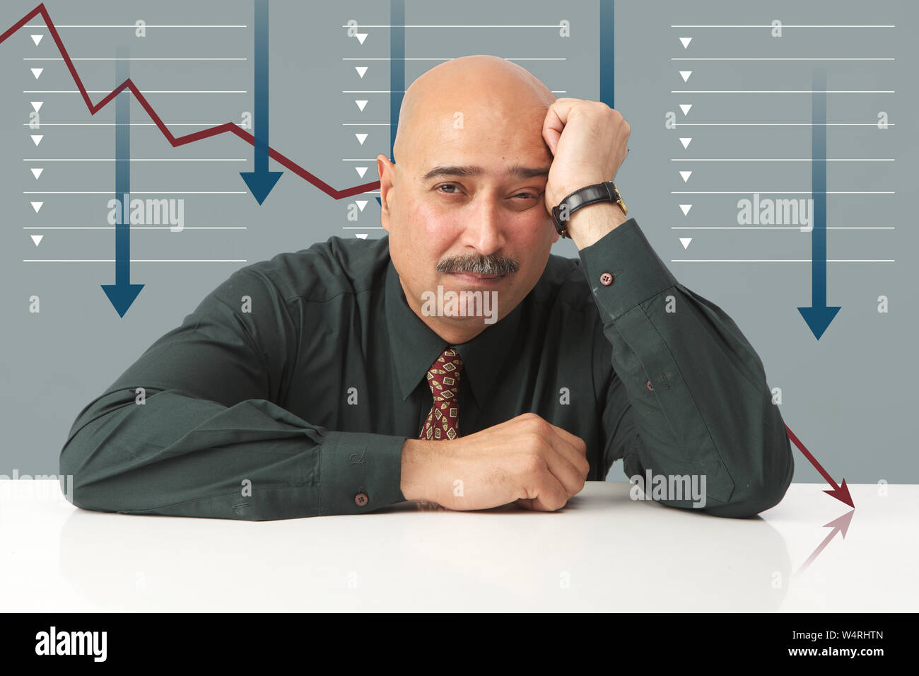 Depressed businessman with his face down in front of line graph moving