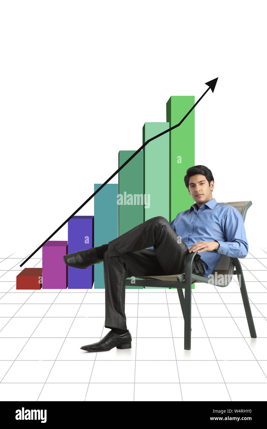 Businessman sitting in front of bar graph rising upward Stock Photo - Alamy