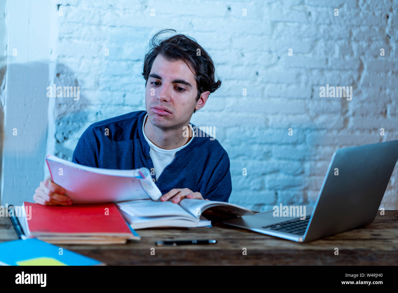 Overworked and Stressed young student preparing exams late at night on ...