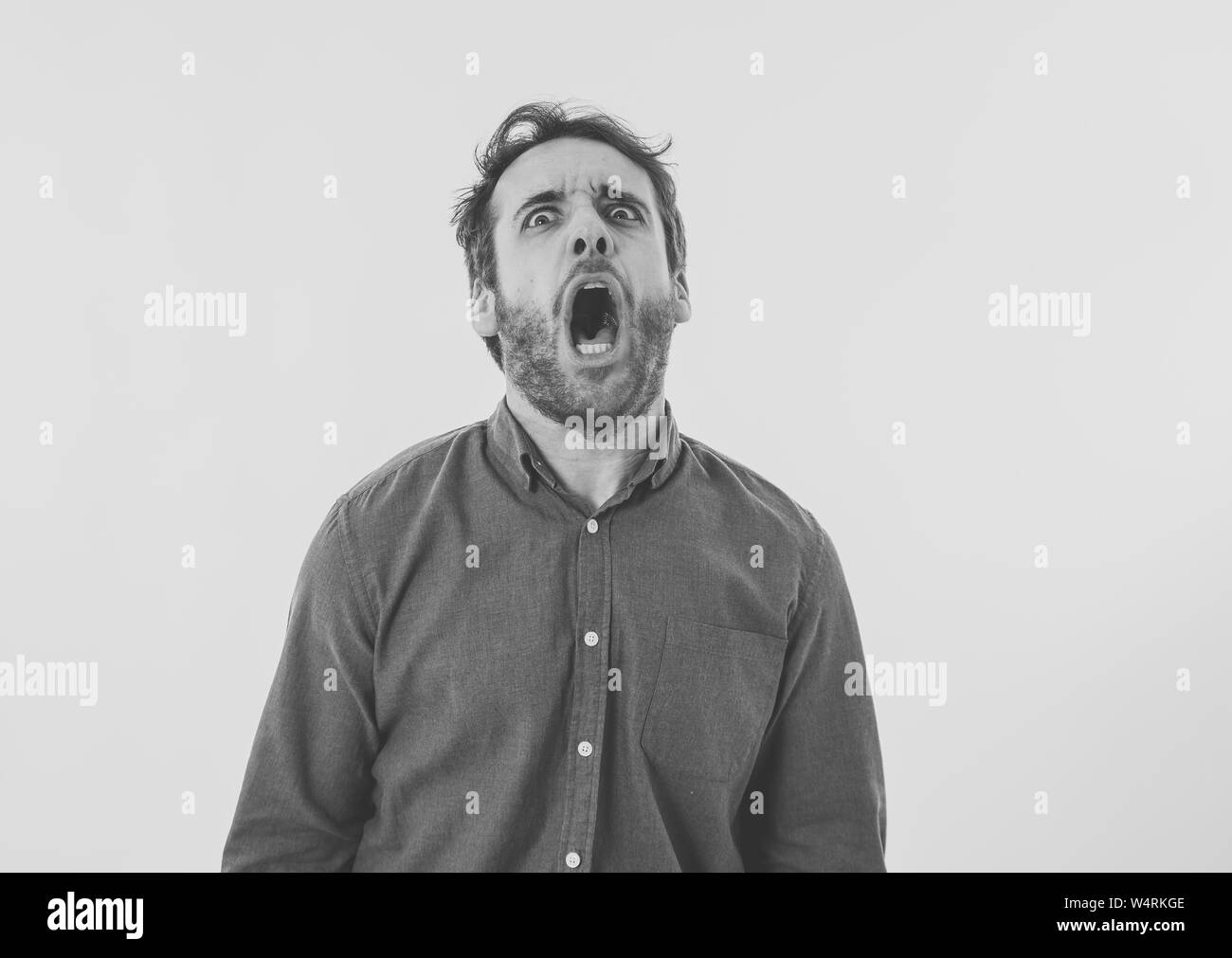 Portrait of young man in shock with scared face paralysed with fear and frightened face looking at something scaring. Human emotions feelings and faci Stock Photo