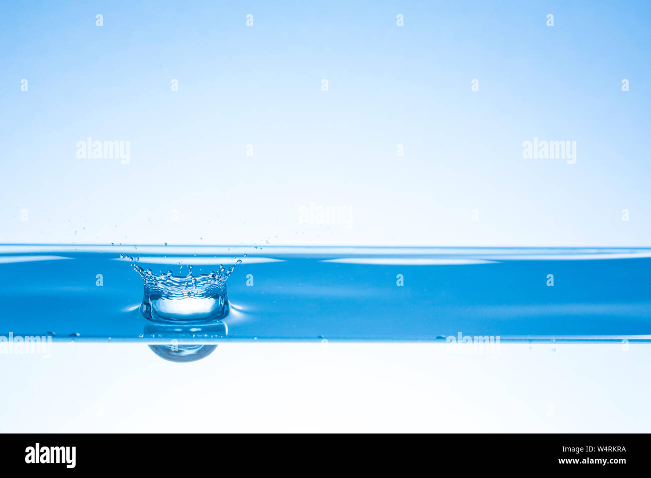 Drop splashing in water Stock Photo