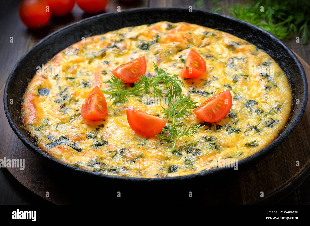 Omelette in frying pan on wooden table, close up Stock Photo