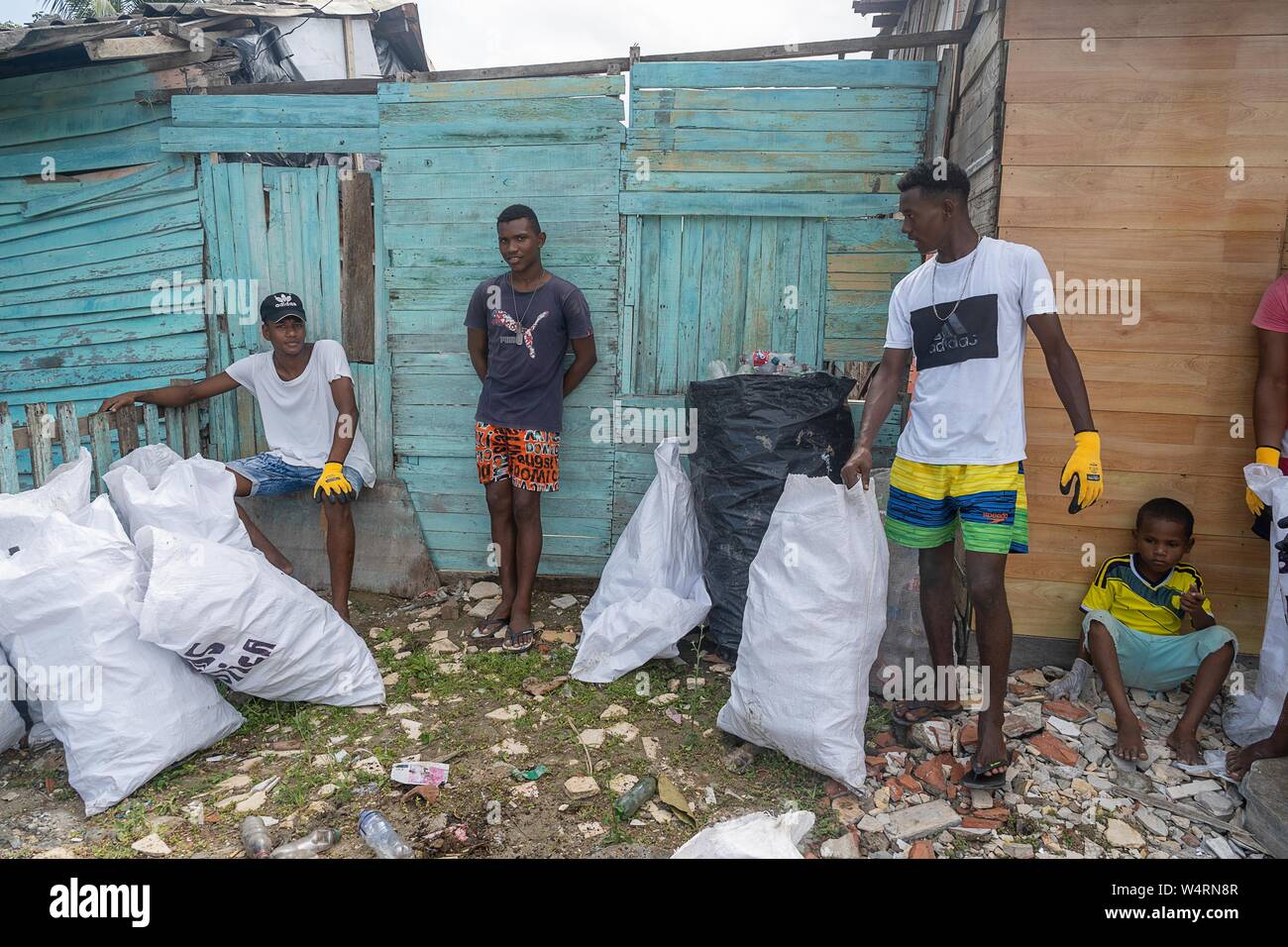 July 24, 2019, Cartagena, Bolivar, Colombia: Young men stand next to sacks  of plastic waste at the La Boquilla during a clean-up session in  Cartagena.Fundacion CoraJeM works in educating and creating opportunities