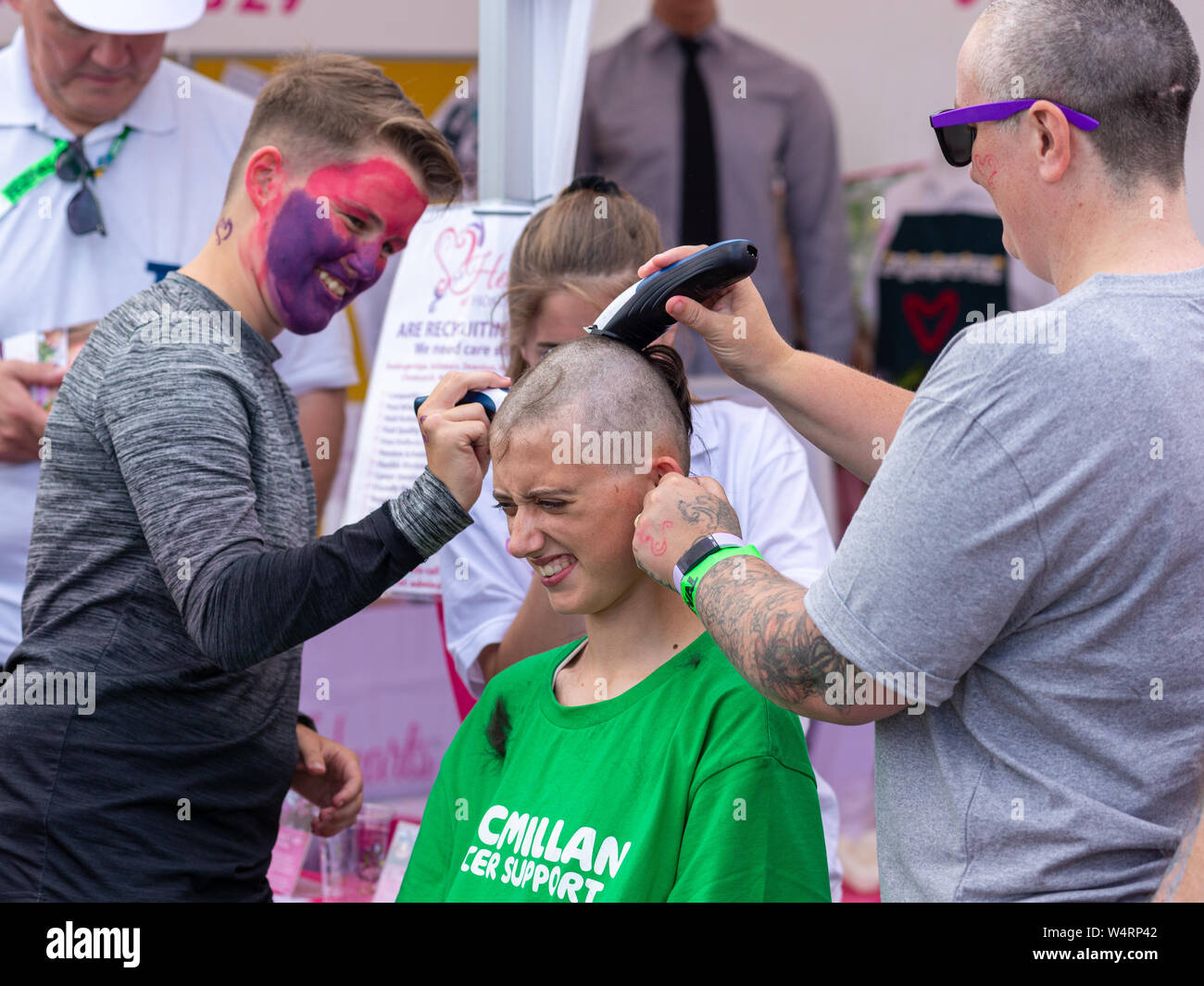 young-woman-having-her-head-shaved-for-charity-at-a-summer-fete