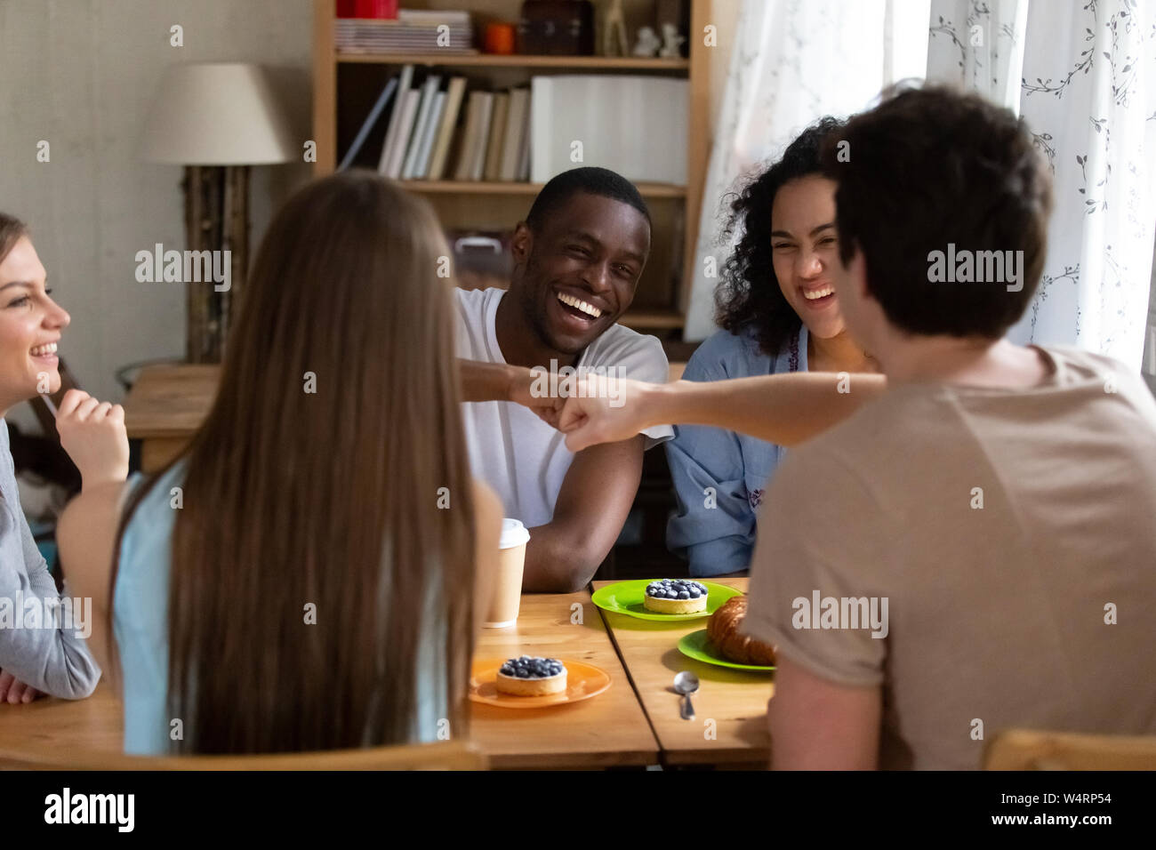 Happy black guy bumping fists with buddy. Stock Photo