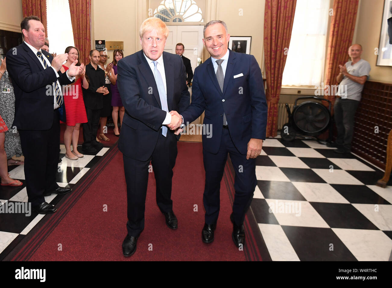 Prime Minister Boris Johnson shaking hands with Sir Mark Sedwill, as he is clapped into 10 Downing Street by Mark Spencer (left) and Dominic Cummings (right) after he accepted the invitation from Queen Elizabeth II to become Prime Minister and form a new government. 24/07/19 Stock Photo