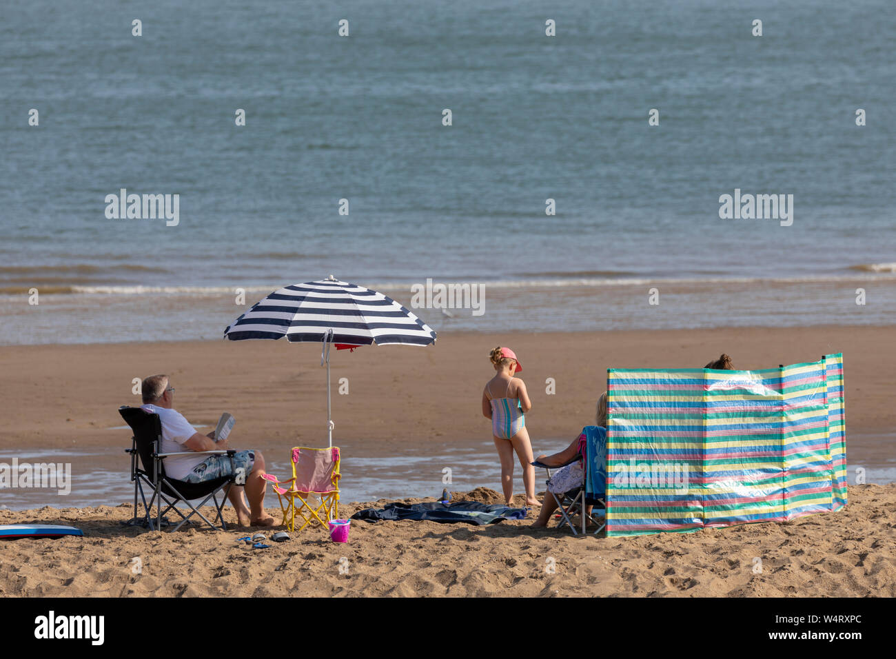 North Wales, UK. 25th July, 2019. UK Weather: Heatwave weather could break UK all time records today for some parts of the UK with temperatures expected to reach the 39C for the south east with many parts above 30C. The North Wales coastline bathed in hot sunshine as the heatwave reaches its peak today as a beach visitors enjoy the weather on Cowlyn Bay Beach, North Wales. Credit: DGDImages/Alamy Live News Stock Photo