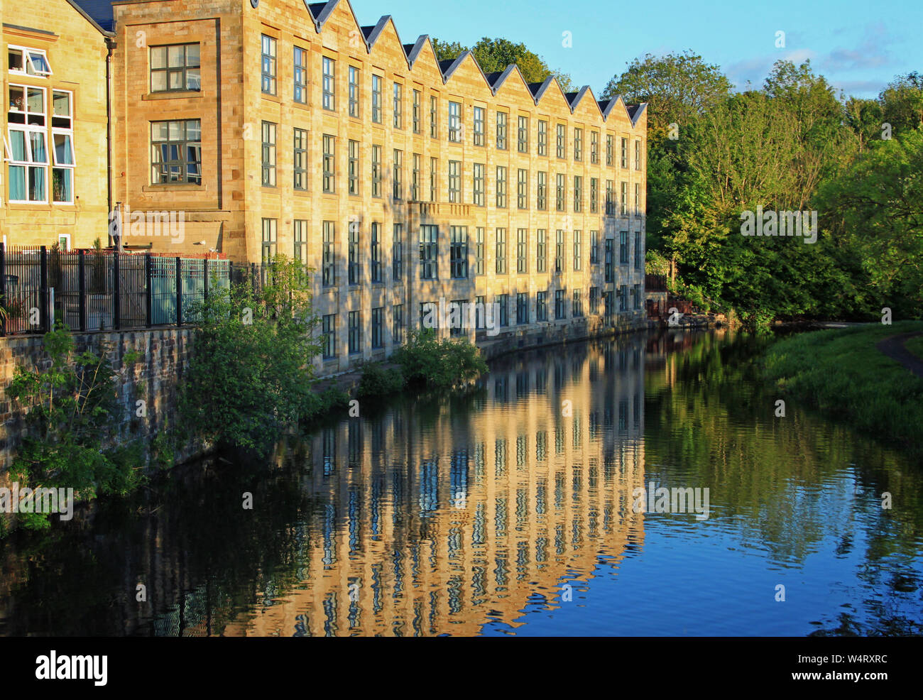 Houses by the side of the Leeds and Liverpool Canal pictured in evening light. This building was one of the Brierfield Mills Stock Photo