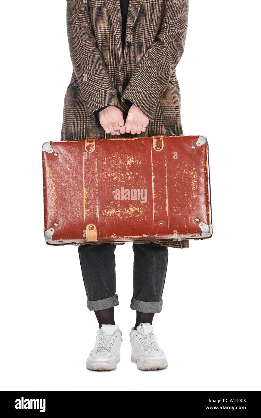 cropped view of woman in plaid coat holding vintage weathered suitcase isolated on white Stock Photo