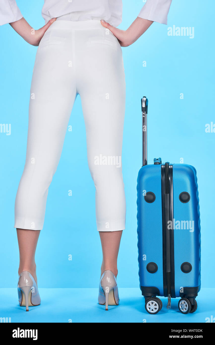 back view of woman standing with hands on hips near blue colorful ...