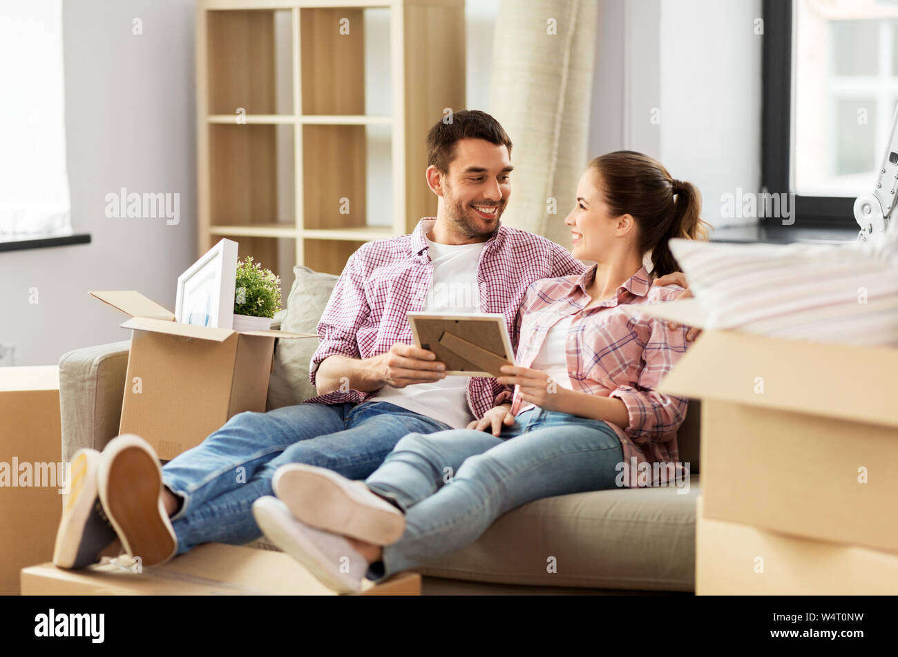 happy couple with boxes moving to new home Stock Photo - Alamy