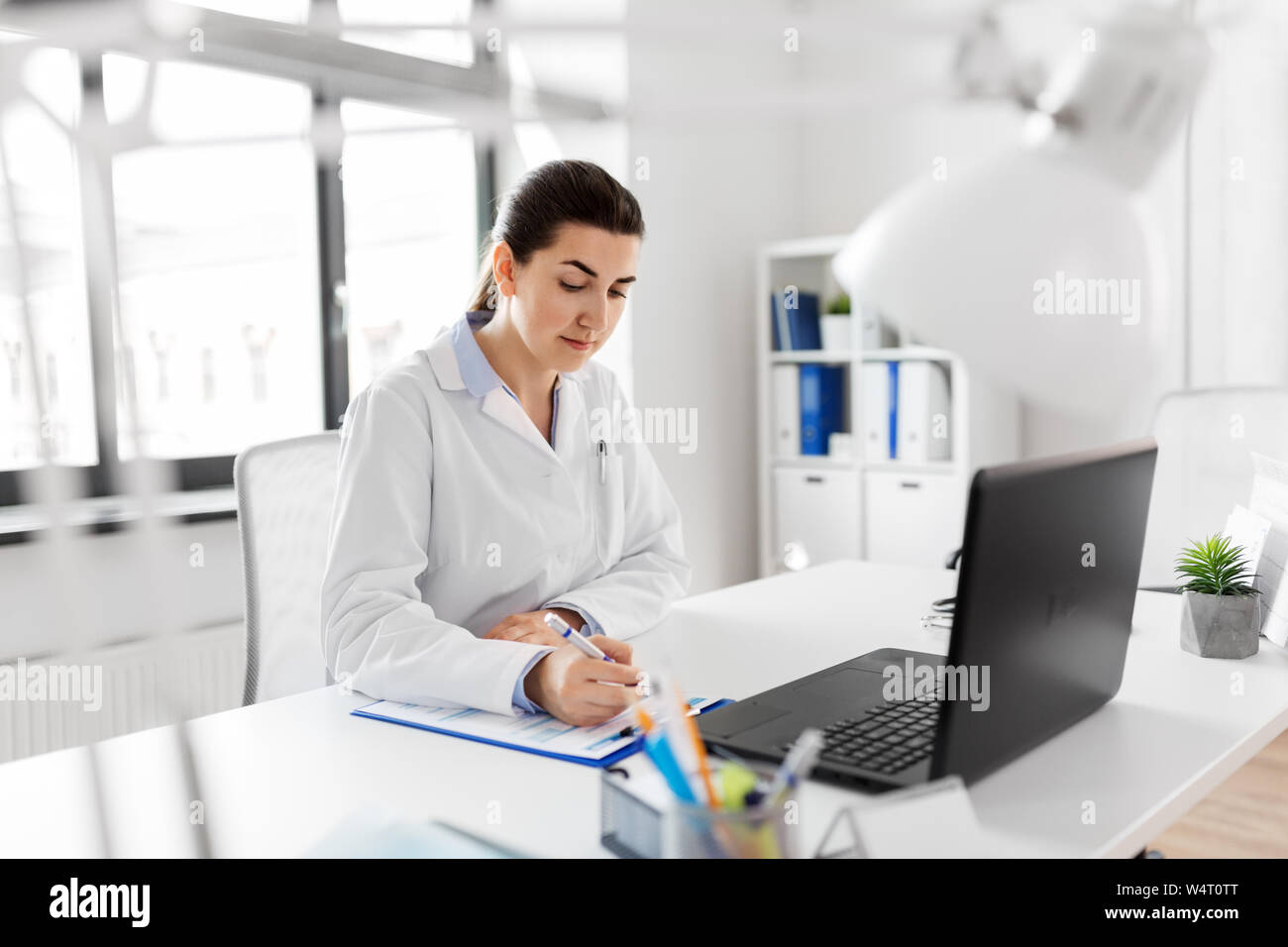 Serious female doctor writing hi-res stock photography and images - Alamy