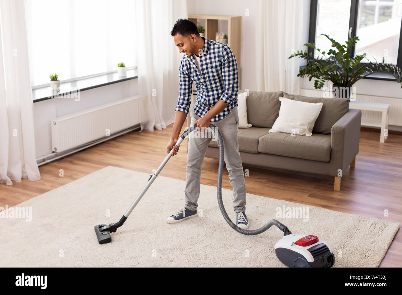 indian man with vacuum cleaner at home Stock Photo Alamy