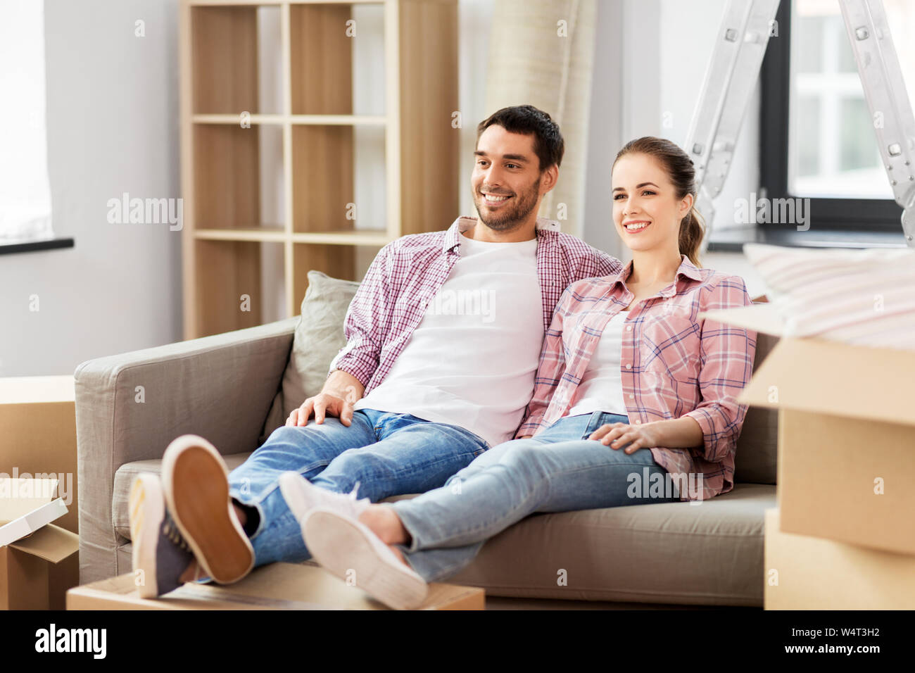 happy couple with boxes moving to new home Stock Photo - Alamy