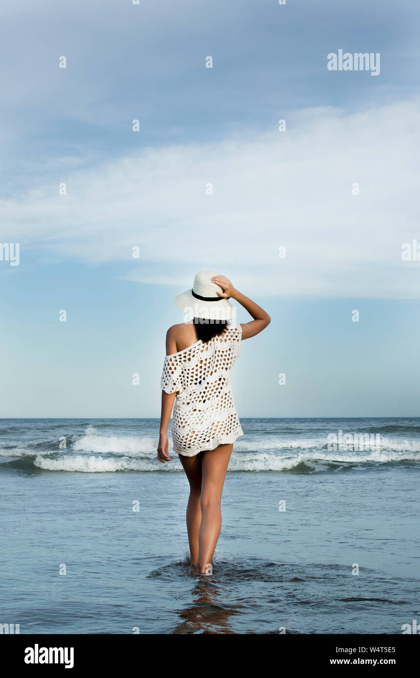Teenage girl walking in the ocean surf, Argentina Stock Photo