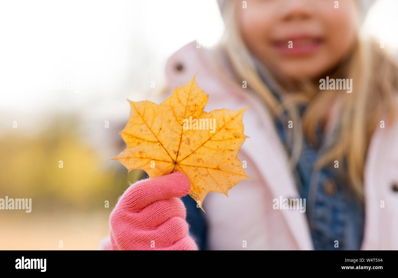 close up of little girl with maple leaf in autumn Stock Photo - Alamy