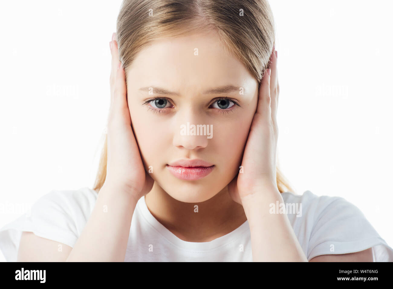 offended teenage girl covering ears with hands isolated on white Stock