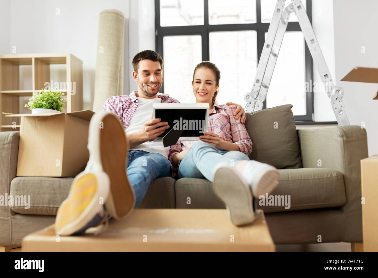 happy couple with boxes moving to new home Stock Photo - Alamy