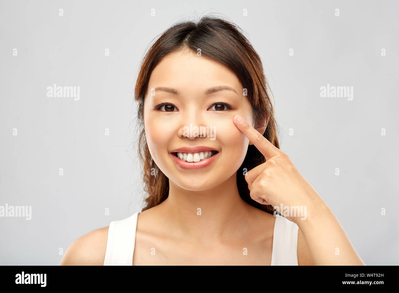 happy smiling young asian woman touching her face Stock Photo - Alamy