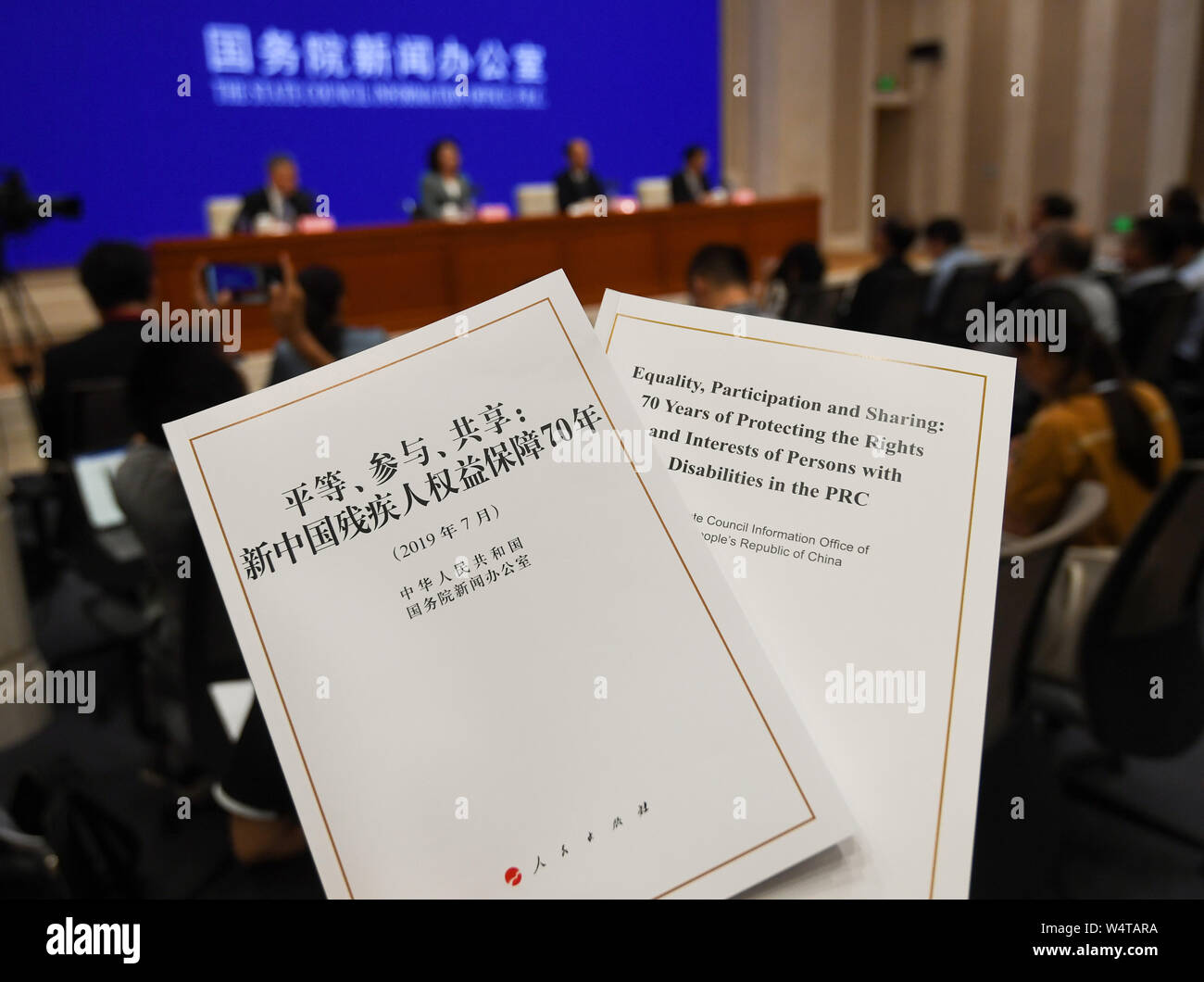 Beijing, China. 25th July, 2019. Photo taken on July 25, 2019 shows the Chinese and English versions of the white paper titled 'Equality, Participation and Sharing: 70 Years of Protecting the Rights and Interests of Persons with Disabilities in the PRC,' during a press conference in Beijing, capital of China. The State Council Information Office on Thursday issued a white paper on the country's efforts to protect rights and interests of persons with disabilities over the past 70 years. Credit: Chen Yehua/Xinhua/Alamy Live News Stock Photo