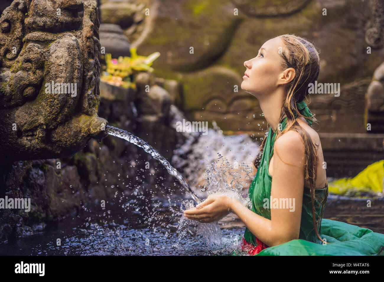 Woman in holy spring water temple in bali. The temple compound consists of a petirtaan or bathing structure, famous for its holy spring water Stock Photo