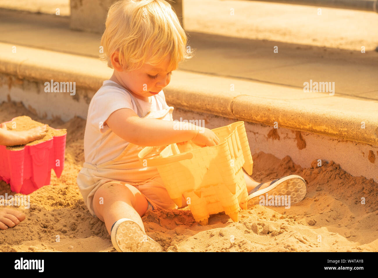 Aberystwyth, Wales, UK. 25th July, 2019.   DEXTER MEDENI OWEN, 19 months old, plays in the sandpit on the beach in Aberystwyth  on yet another scorching  day as a plume of hot air continues dominate the UK, with the likelihood of record breaking temperatures  of 38 or 39ºc in parts of the south east this afternoon. Photo credit Keith Morris / Alamy Live News Stock Photo
