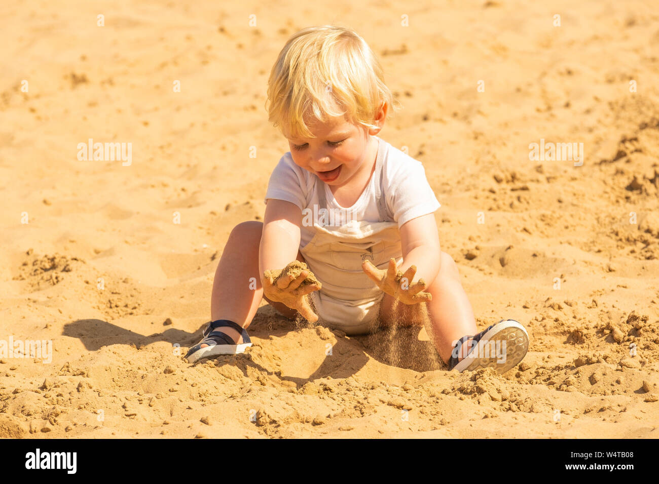Aberystwyth, Wales, UK. 25th July, 2019.   DEXTER MEDENI OWEN, 19 months old, plays in the sandpit on the beach in Aberystwyth  on yet another scorching  day as a plume of hot air continues dominate the UK, with the likelihood of record breaking temperatures  of 38 or 39ºc in parts of the south east this afternoon. Photo credit Keith Morris / Alamy Live News Stock Photo