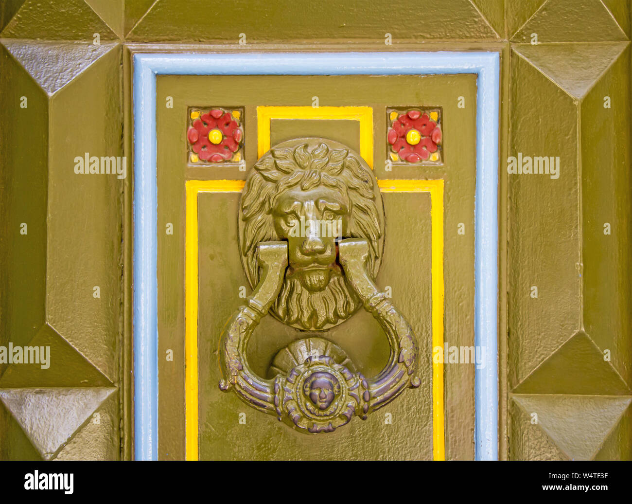 Old metal doorknob in the shape of lion head on old wooden door Stock Photo