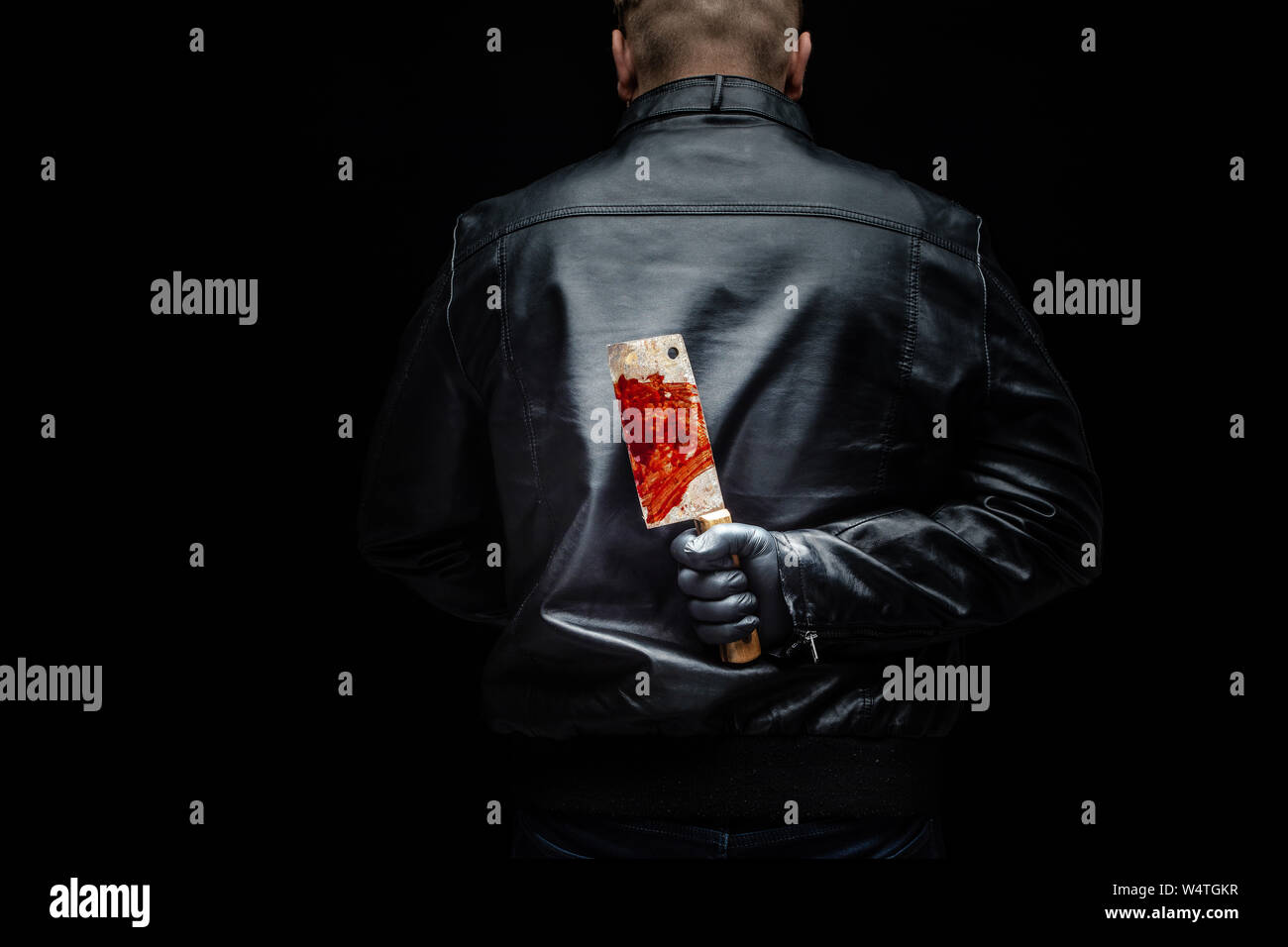 Serial killer maniac holding killer tools behind his back Stock Photo