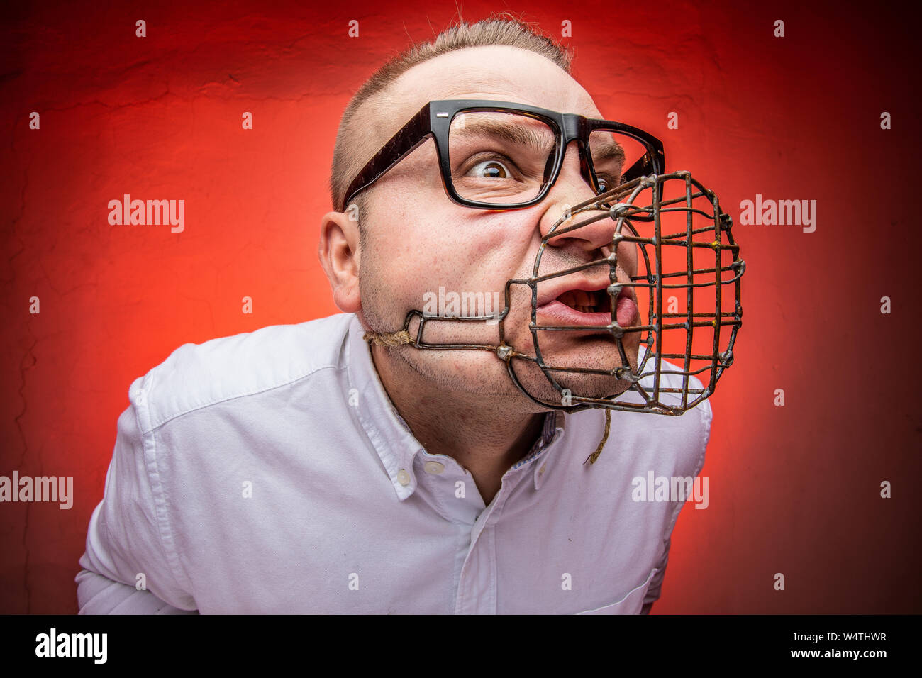 Angry and agressive man with dog muzzle basket shouting Stock Photo