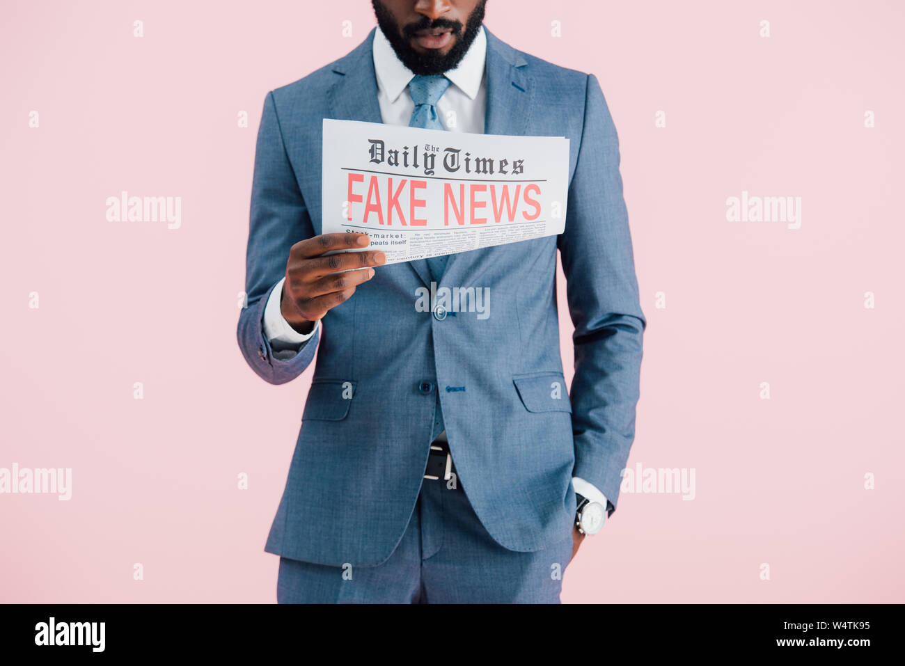 cropped view of african american businessman reading newspaper with ...