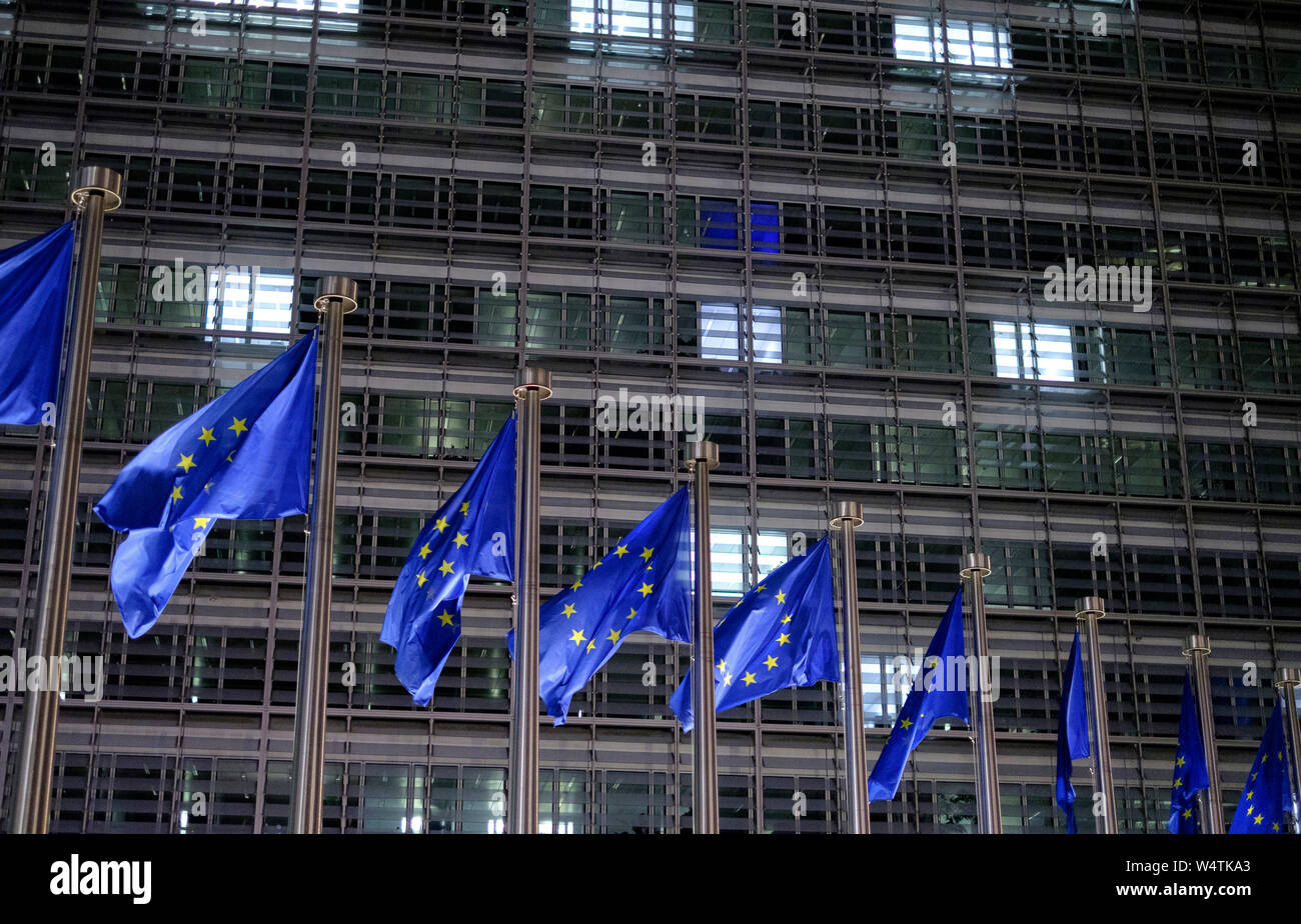 Belgium, Brussels: European flags in front of the Berlaymont building, headquarters of the European Commission. European Flag, consisting of a circle Stock Photo