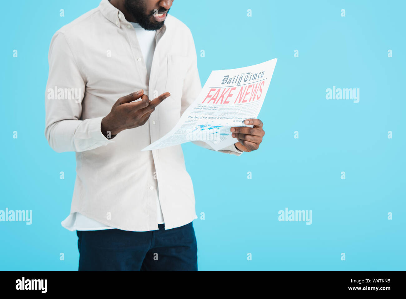 cropped view of aggressive african american man reading newspaper with ...