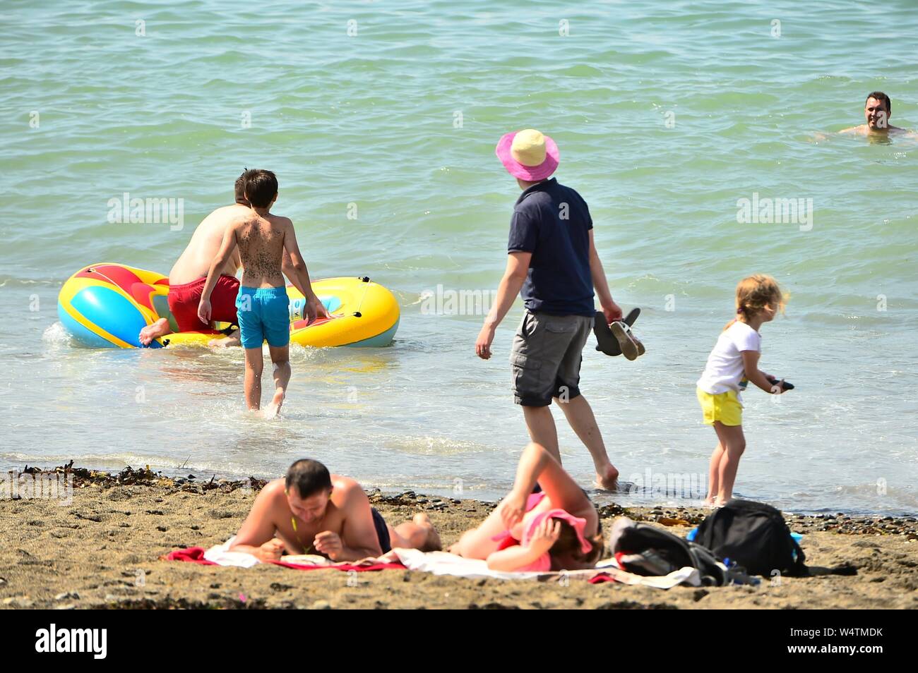 Aberystwyth, UK. 25th July, 2019.  UK weather: People at the seaside in Aberystwyth, west Wales, on yet another scorching day as a plume of hot air continues dominate the UK, with the likelihood of record breaking temperatures of 38 or 39ºc in parts of the south east this afternoon. Photo Credit: keith morris/Alamy Live News Stock Photo