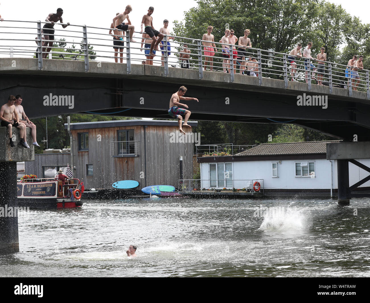 People leap from a bridge at Taggs Island, near Hampton Court, Surrey, as the UK has surpassed the hottest July day on record, with 36.9 degrees celsius being recorded at Heathrow. The all-time UK record of 38.5C (101.3F) recorded in Faversham, Kent, in August 2003, could be broken on Thursday, the Met Office said. Stock Photo