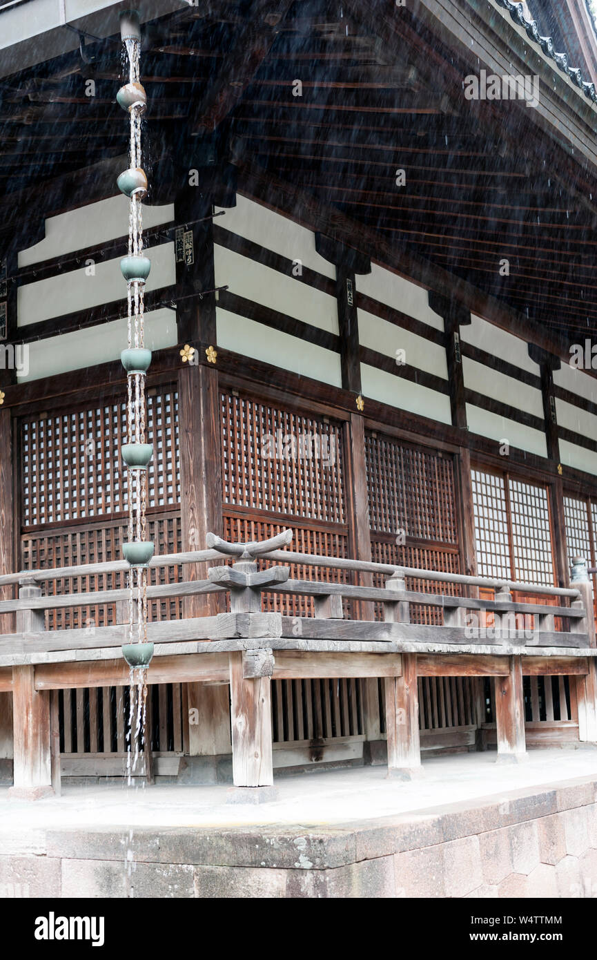 Oyama Shrine seen in heavy rain with water pouring down chain downpipe, Kanazawa, Japan. Stock Photo