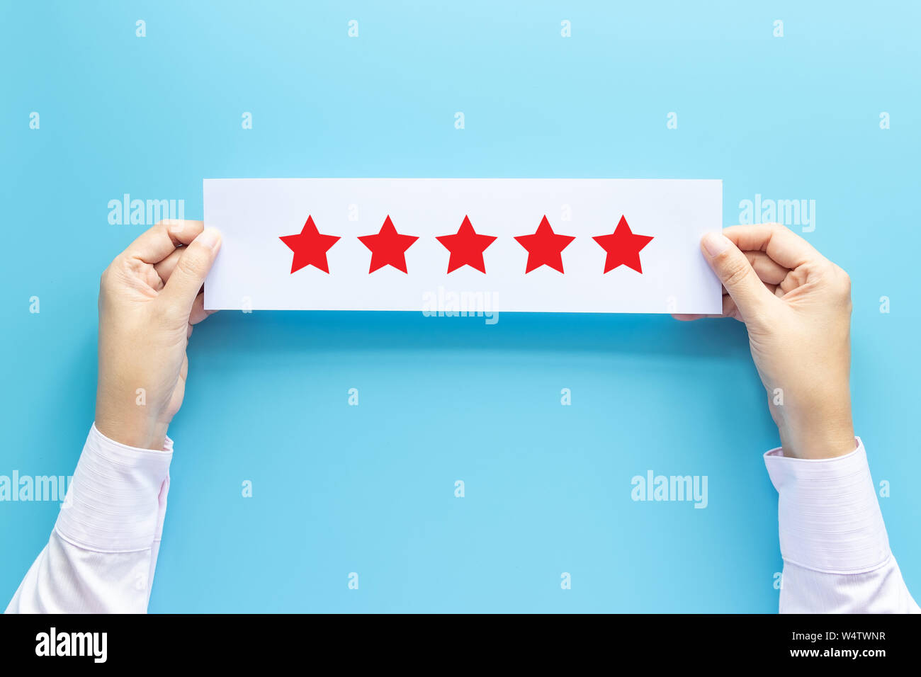 rating and feedback concept. customer holding paper with satisfied review by give five star for service experience Stock Photo