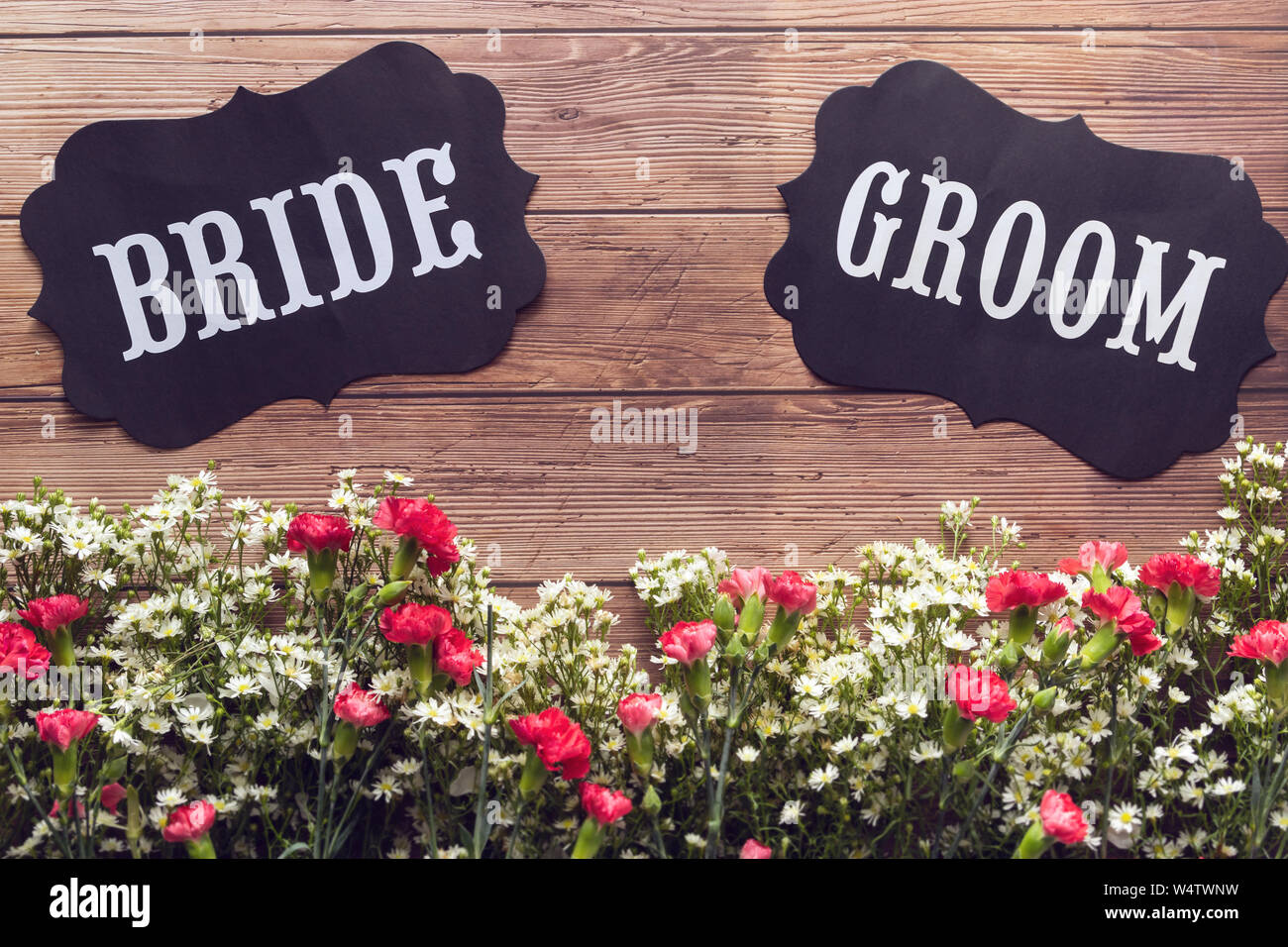 Bride and Groom text sign on wooden background decorated with flower, vintage style. wedding invitation and greeting card Stock Photo